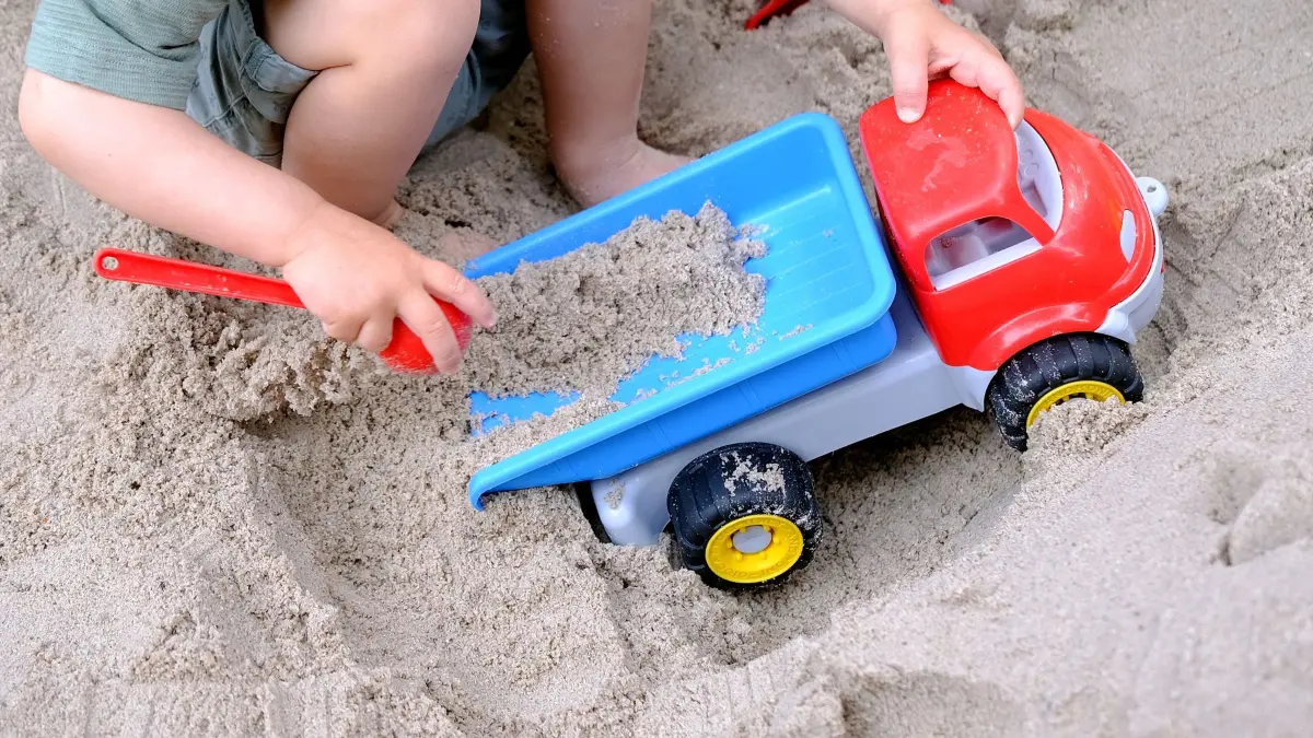 Kleinkind spielt im Sandkasten