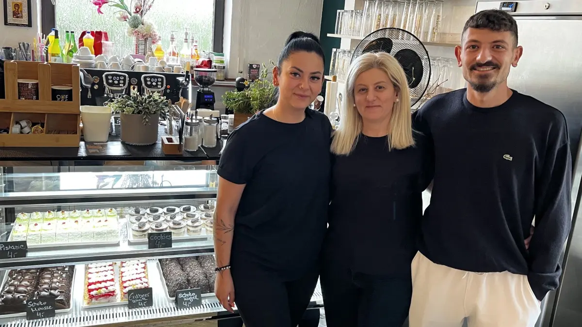 Das Team vom Café Freddo mit Fey, Maria und Pana Mavroudi vor der Kuchenvitrine.