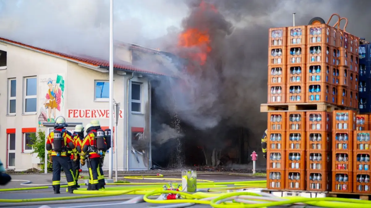 Feuerwehrhaus in Landkreis Esslingen brennt: 15.06.2026, Baden-Württemberg, Unterensingen: Feuerwehrleute stehen vor dem brennenden Gerätehaus der Feuerwehr Unterensingen. Bei dem Brand im Landkreis Esslingen ist ein Schaden von etwa 10 Millionen Euro entstanden. Vier Fahrzeuge, ein Boot und mehrere Gerätschaften wurden zerstört, das Gebäude sei erheblich beschädigt worden, teilte ein Polizeisprecher mit. Foto: -/SDMG/dpa +++ dpa-Bildfunk +++