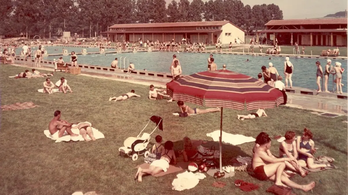 Durchschnittlich 17,5 Grad beträgt die Wassertemperatur in den Anfangszeiten des Freibads. Der Eintritt kostet 50 Pfennig (ermäßigt 40 Pfennig). Den Kinderbereich und das Eingangsgebäude werden aus Kostengründen erst einige Jahre nach der Freibad-Eröffnung gebaut. Auf dieser Farbaufnahme aus dem Jahr 1951 oder 1952 ist vom Eingangsbereich noch nichts zu sehen.