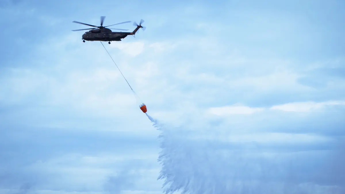 Die CH-53 im Übungs-Löscheinsatz. Der Abwurf des Wassers zur Brandbekämpfung erfordert ein hohes Maß an Konzentration und Timing.