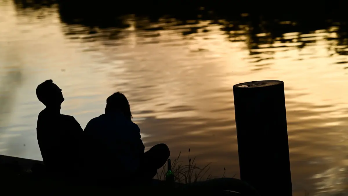 Wetter Berlin: 16.06.2026, Berlin: Ein Paar sitzt im Abendlicht am Landwehrkanal. Foto: Sebastian Gollnow/dpa +++ dpa-Bildfunk +++