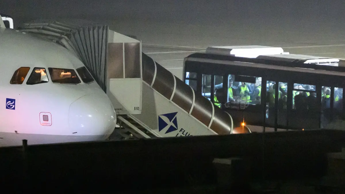Abschiebeflug nach Afghanistan: 15.06.2026, Sachsen, Leipzig: Ein Bus mit Passagieren hält nach Mitternacht auf dem Flughafen Leipzig/Halle neben einer Maschine. Das Flugzeug startet am frühen Morgen als Abschiebeflug nach Afghanistan. Foto: Hendrik Schmidt/dpa +++ dpa-Bildfunk +++