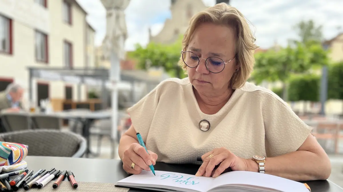 Während andere zum Smartphone greifen, um den Moment festzuhalten, zückt Vero Bobke den Stift. Unter den Türmen des Zwiefalter Münsters entsteht gerade eine neue Seite ihres Kalligrafie-Tagebuchs.