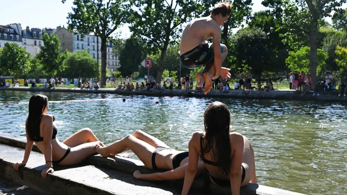 Frankreich - Wetter: 17.06.2026, Frankreich, Paris: Am ersten Tag, an dem das Baden im Canal Saint-Martin in Paris offiziell erlaubt ist, springt ein junger Mann ins Wasser. In der französischen Hauptstadt ist es derzeit heiß. Die Temperaturen steigen über 30 Grad. Foto: Emma Da Silva/AP/dpa +++ dpa-Bildfunk +++