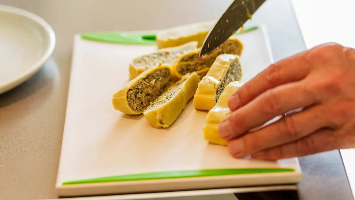 Maultaschen-Blogger Volker Klenk: PRODUKTION - 17.06.2026, Hessen, Kronberg: Klassische Maultaschen mit Fleisch nach Oma Lisbeths Rezept werden zum Anbraten in Streifen geschnitten. Der Schwabe Volker Klenk ist von der Magie von Maultaschen begeistert. Als Blogger, Buchautor und Inhaber von Oma Lisbeths Maultaschen. (zu dpa: «Der Mann, der sogar von Maultaschen träumt») Foto: Andreas Arnold/dpa +++ dpa-Bildfunk +++