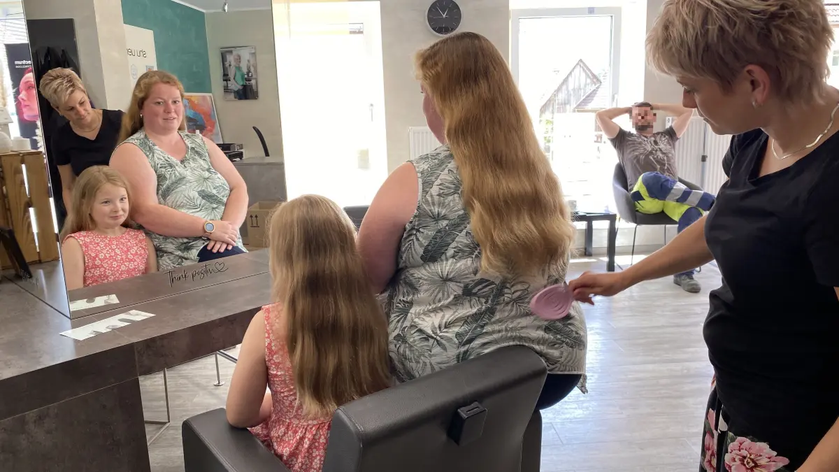 Ann-Kathrin Beck und Tochter Maja beim gemeinsamen Friseurtermin. Die langen Haare, die Friseurmeisterin Vanessa Knodel gleich abschneidet, werden gespendet.