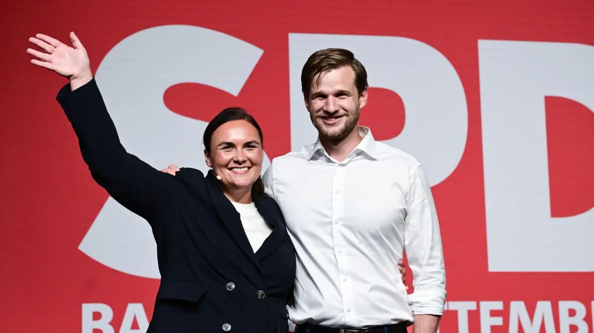 Landesparteitag der SPD Baden-Württemberg: 19.06.2026, Baden-Württemberg, Ulm: Isabel Cademartori und Robin Mesarosch stehen in der Donauhalle beim Landesparteitag der SPD Baden-Württemberg nach ihrer Wahl zu den neuen Landesvorsitzenden als Doppelspitze auf der Bühne. Im Mittelpunkt des zweitägigen Parteitags sollen die inhaltliche, strukturelle und personelle Neuausrichtung der Partei stehen sowie die Neuwahlen des gesamten Landesvorstands. Foto: Bernd Weißbrod/dpa +++ dpa-Bildfunk +++