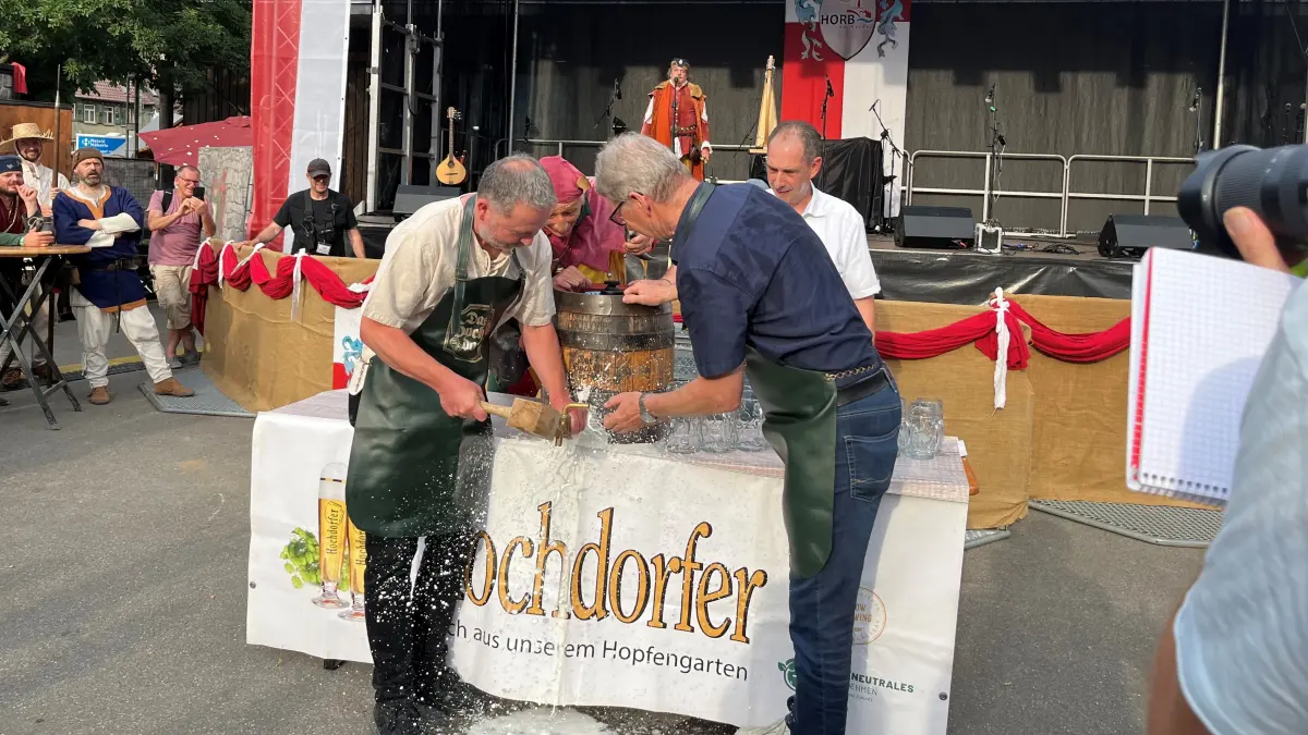 Rettet das Bier! Bei seinem ersten Fassanstich macht ein verkanteter Zapfen Oberbürgermeister Michael Keßler das Leben schwer. Eberhard Haizmann von der Hochdorfer Kronenbrauerei (rechts) und Maxx der Narr versuchen, ihm zu helfen.