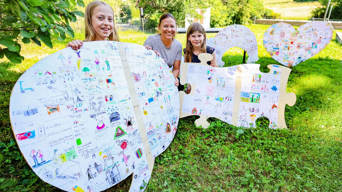 Kinderrechte: Grundschulen aus Schwäbisch Hall beteiligen sich mit Schulsozialarbeitern an einem Projekt. Weil die Holzschilder aus Brandschutzgründen nicht aufgehängt werden durften, schlummerten sie jetzt über Jahre in den Büros der Schulsozialarbeiter. Irmingard Sautter (9) und Elise-Lotte Kiesler (9) haben jetzt eigenständig eine Ausstellung im Brenzhaus organisiert. Mit dabei ist Schulsozialarbeiterin Marion Klingler. Grundschule Steinbach