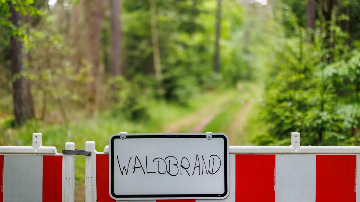 Waldbrand: ARCHIV - 22.05.2025, Bayern, Erlangen: "Waldbrand" steht auf dem Schild an einem Absperrzaun im Tenneloher Forst bei Erlangen. (zu dpa: «Waldbrandgefahr: In Mittelfranken starten Beobachtungsflüge») Foto: Daniel Karmann/dpa +++ dpa-Bildfunk +++