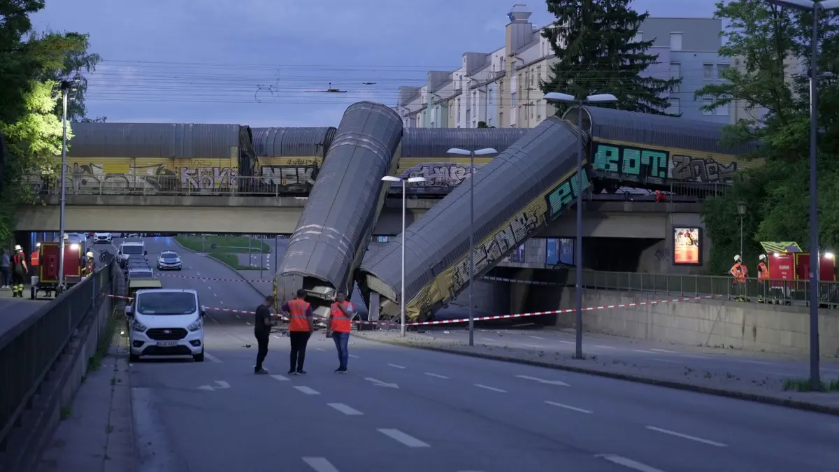 Güterzug stürzt in München von Brücke: 20.06.2026, Bayern, München: Zwei Waggons eines Güterzugs liegen auf einer Straße, nachdem sie von einer Brücke gestürzt sind. Foto: Ehsan Monajati/dpa +++ dpa-Bildfunk +++