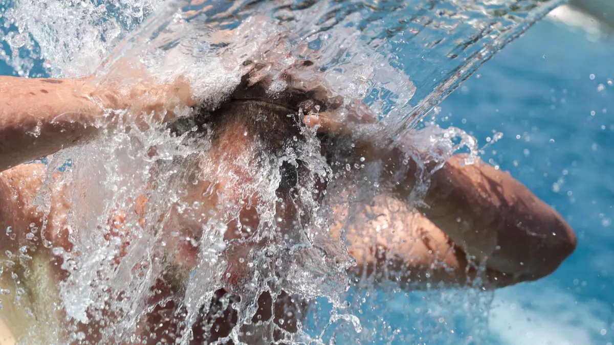Hitze in Deutschland Wetter - Baden-Württemberg: 21.06.2026, Baden-Württemberg, Sigmaringen: Ein Mann steht bei Temperaturen von über 30 Grad im Freibad unter einer Wasserfontäne. Foto: Thomas Warnack/dpa +++ dpa-Bildfunk +++