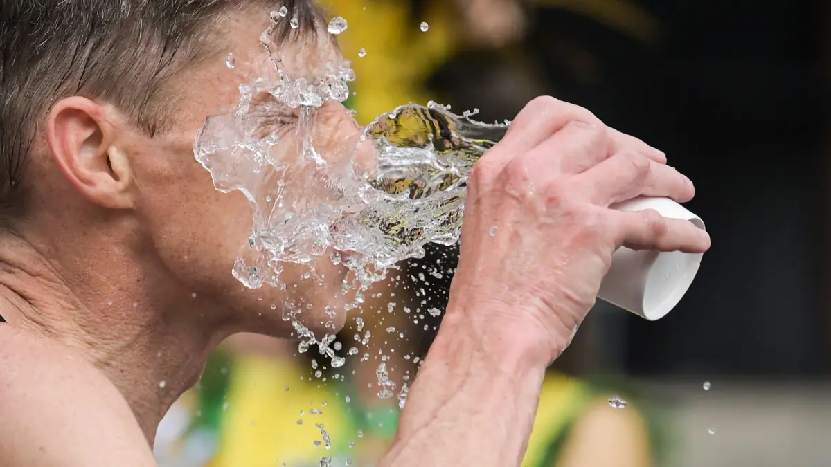 Ein Mann schüttet sich Wasser ins Gesicht: ARCHIV - 07.05.2023, Rheinland-Pfalz, Mainz: Abkühlung: Lauwarmes Wasser schont den Kreislauf besser als eiskaltes. (zu dpa: «Hitze dreht noch auf - bis 39 Grad ab Mittwoch») Foto: Sebastian Gollnow/dpa/dpa-tmn +++ dpa-Bildfunk +++