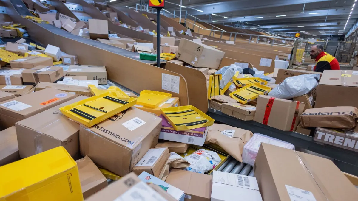 Paketmenge steigt: ARCHIV - 04.12.2025, Nordrhein-Westfalen, Köln: Ein Paketzusteller sortiert und räumt in einer Zustellbasis von Deutsche Post DHL Pakete in ein Zustellfahrzeug. Die Paketmenge in Deutschland ist im vergangenen Jahr gestiegen, wie eine Studie des Branchenverbandes BPEX ergab. (zu dpa: «Es werden mehr Pakete verschickt in Deutschland») Foto: Rolf Vennenbernd/dpa +++ dpa-Bildfunk +++
