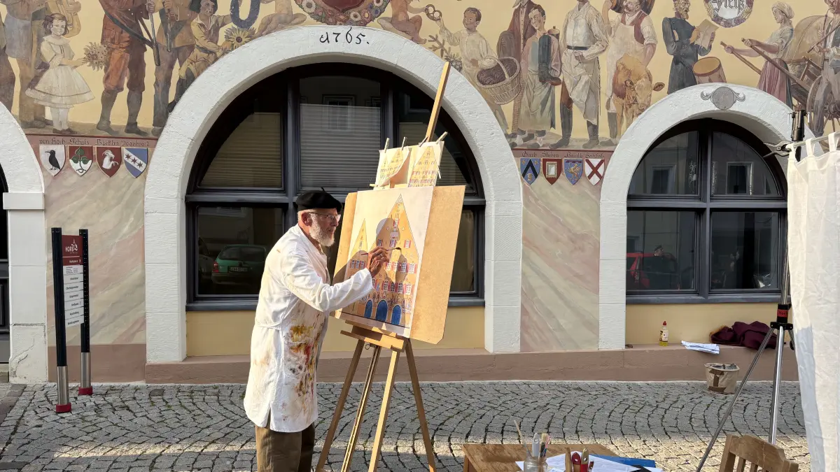 Der zum Leben erwachte Bildhauer und Maler Wilhelm Klink (gespielt von Rainer Kipp) malt das "Bilderbuch" auf die Leinwand.
