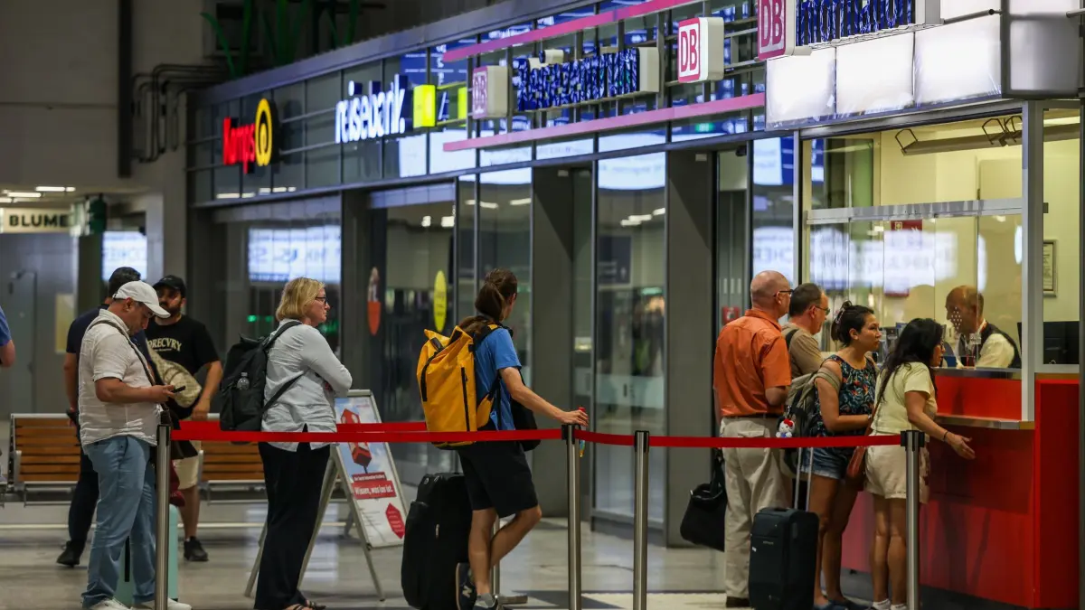 Bahnverkehr wegen Funkstörung bundesweit eingestellt: 23.06.2026, Nordrhein-Westfalen, Duisburg: Fahrgäste stehen am Informationsschalter der DB am Bahnhof Duisburg Schlange. Der Verkehr der Deutschen Bahn ist wegen einer Funkstörung bundesweit eingestellt. Foto: Christoph Reichwein/dpa +++ dpa-Bildfunk +++