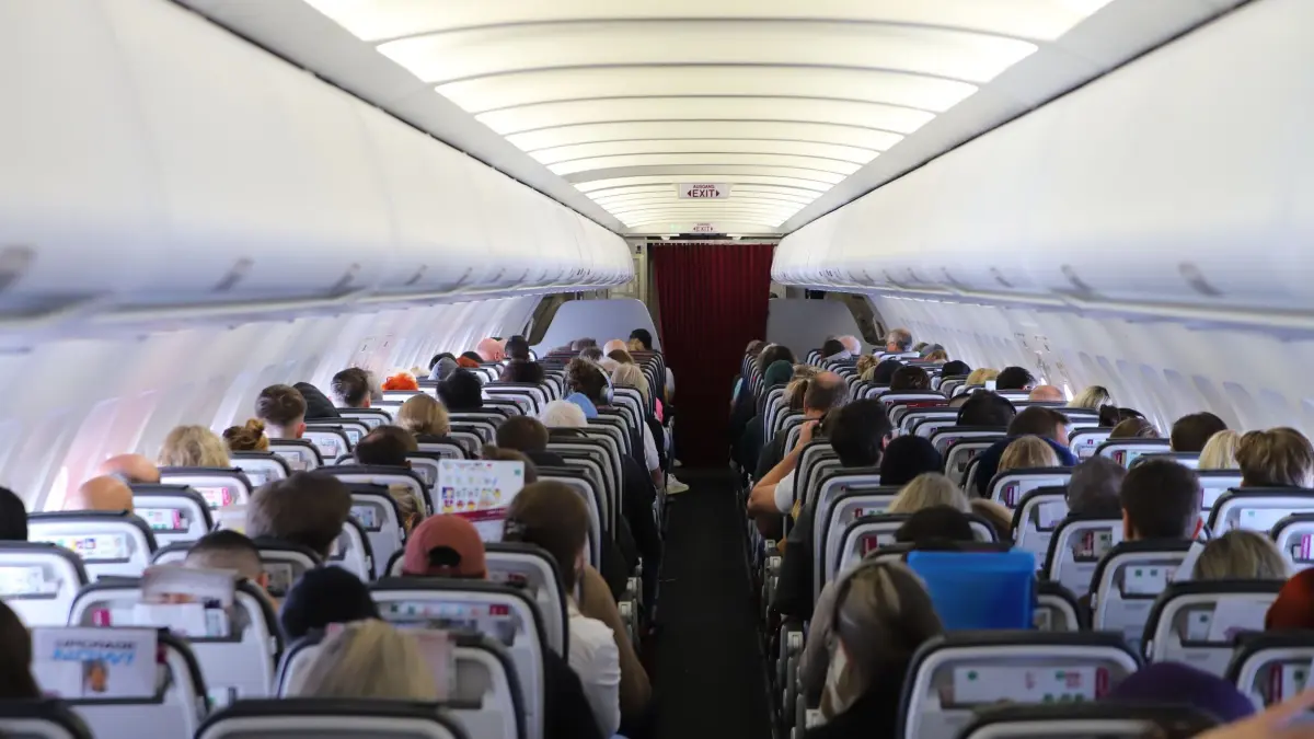 Passagiere sitzen in der Kabine eines Flugzeugs: ARCHIV - Bloßes Unwohlsein, Kreislaufbeschwerden oder Kopfschmerzen reichen rechtlich nicht aus, um bei einer überhitzten Kabine Anspruch auf Schmerzensgeld gegenüber der Airline geltend machen zu können. (zu dpa: «Hitze im Flugzeug: Diese Rechte haben Urlauber») Foto: Sascha Thelen/dpa/dpa-mag - Honorarfrei nur für Bezieher des Dienstes dpa-Magazin +++ dpa-Magazin +++