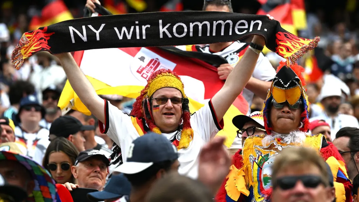 WM 2026 - Ecuador - Deutschland: 25.06.2026, USA, East Rutherford: Fußball, Männer, WM 2026, Ecuador - Deutschland, Vorrunde, Gruppe E, Spieltag 3, New York -New Jersey -Stadion, ein Deutschland-Fan und ein Fan von Ecuador stehen vor dem Spiel auf der Tribüne zusammen. ACHTUNG: Gemäß den Auflagen der FIFA dürfen die Bilder ausschließlich zur redaktionellen Verwendung genutzt werden. Eine kommerzielle Nutzung ist ausgeschlossen. Zudem dürfen keine videoähnlichen Sequenzen erstellt werden, und es dürfen keine Veränderungen weder im Vordergrund noch im Hintergrund am Bild vorgenommen werden. Foto: Federico Gambarini/dpa +++ dpa-Bildfunk +++