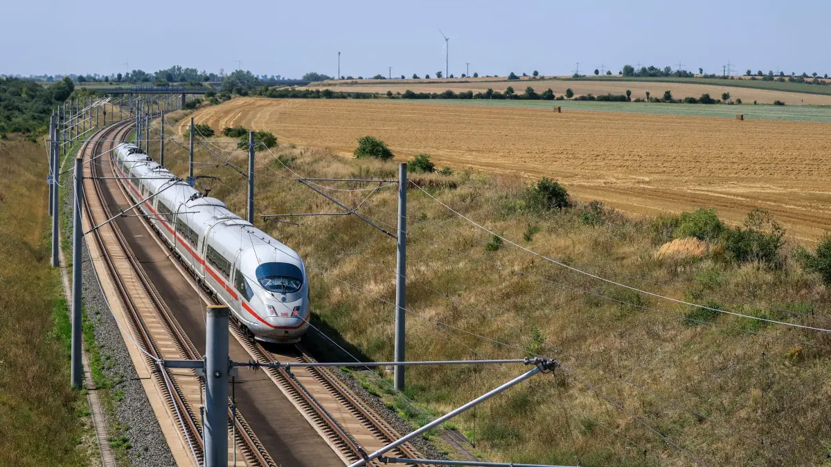 Hitze: ARCHIV - 13.08.2025, Sachsen-Anhalt, Bad Lauchstädt: Ein ICE der Deutschen Bahn fährt zwischen abgeernteten Feldern auf der Neubaustrecke München-Berlin. (zu dpa: «Bahn bietet kostenlose Stornierung für Hitze-Tage an») Foto: Jan Woitas/dpa +++ dpa-Bildfunk +++