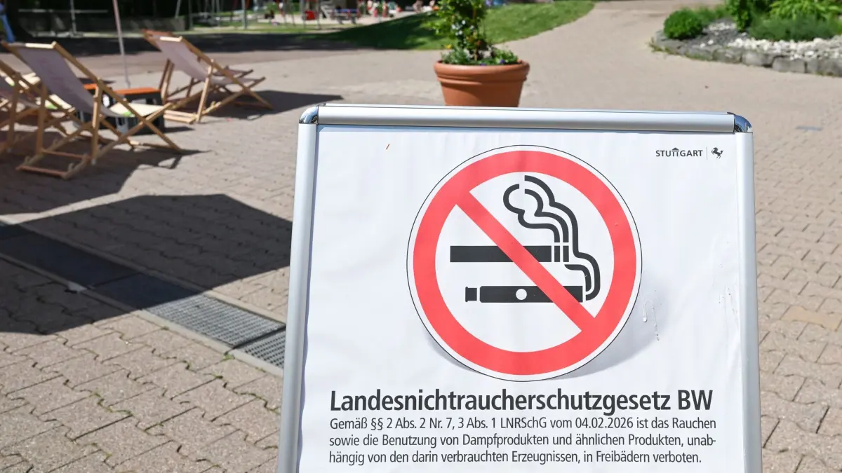Ein Hinweisschild mit Rauchverbot-Symbol informiert in einem Freibad über das «Landesnichtraucherschutzgesetz BW» und ein Rauchverbot auf dem Gelände.
