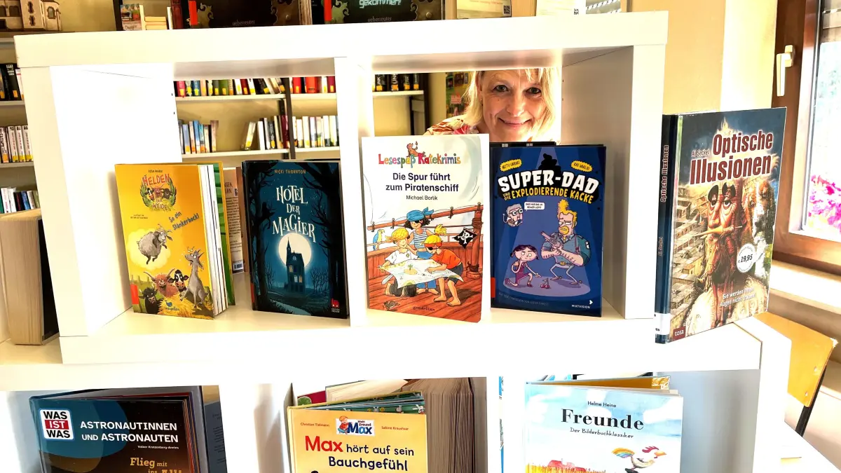 Sabine Scherrmann gehört seit 40 Jahren zum Team der katholischen öffentlichen Bücherei in Fischingen. Fürs Foto blickt sie durchs Bücherregal.