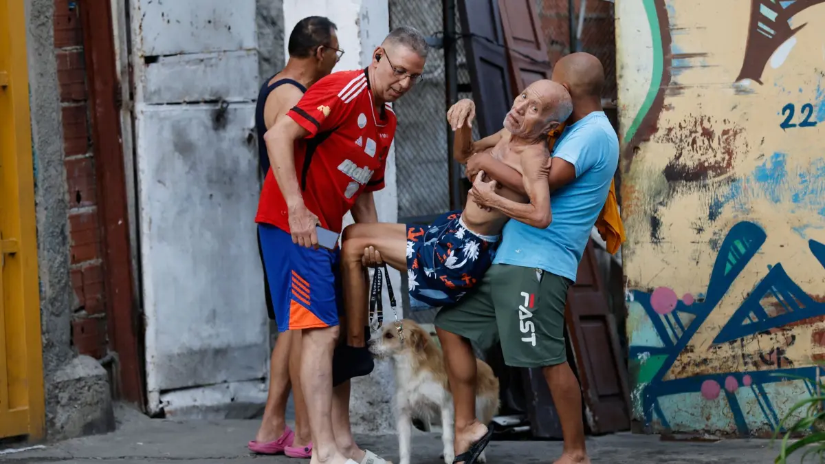 Erdbeben in Venezuela: 25.06.2026, Venezuela, Caracas: Nach einem Erdbeben helfen Nachbarn einem Mann dabei aus seinem beschädigten Haus zu gelangen. Foto: Pedro Mattey/AP/dpa +++ dpa-Bildfunk +++