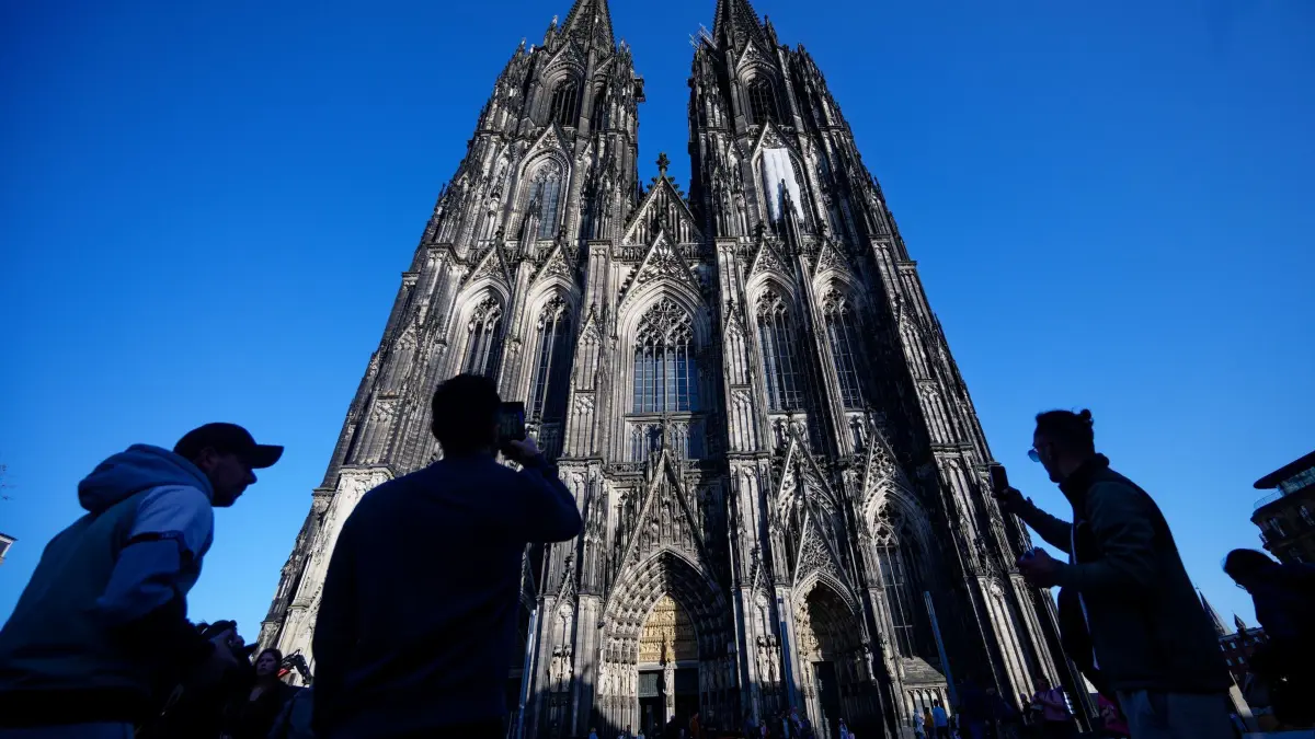 Rente, Steuern, Flüge - was sich im Juli ändert: ARCHIV - 05.03.2026, Nordrhein-Westfalen, Köln: Touristen fotografieren den Kölner Dom. (zu dpa: «Rente, Steuern, Flüge — was sich im Juli ändert») Foto: Henning Kaiser/dpa +++ dpa-Bildfunk +++