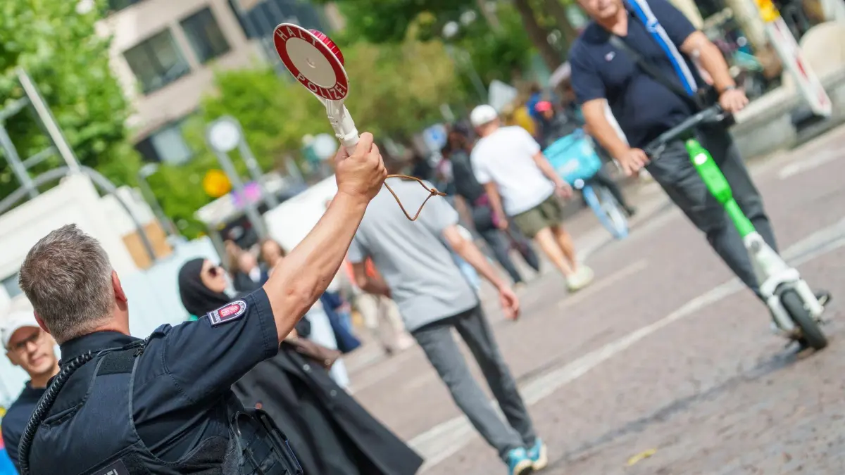 E-Scooterkontrolle in der Innenstadt: ARCHIV - 22.07.2025, Hessen, Frankfurt/Main: Ein E-Scooter-Nutzer wird von der Stadtpolizei auf der «Fressgass» in Frankfurt angehalten. (zu dpa: «Prozess um Tod bei E-Scooter-Unfall - Frage nach Sicherheit») Foto: Andreas Arnold/dpa +++ dpa-Bildfunk +++