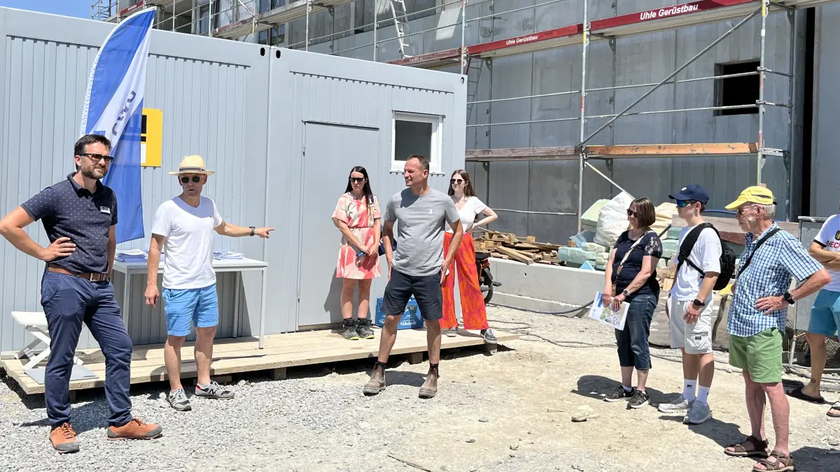 Tag der Architektur 2026 mit dem Motto "Einfach bauen": GWG-Prokurist René Eder (dunkelblaues Polo-Shirt) und Architekt Martin Kuhn stellen das Projekt Schenkenhöhe vor. Es befindet sich in Hessental am Eingang zum Wohngebiet Sonnenrain. Im Gebäudekomplex Schenkenhöhe sollen in fünf Häusern ein Edeka-Markt, 117 Wohnungen, eine Arztpraxis und eine Gaststätte entstehen.