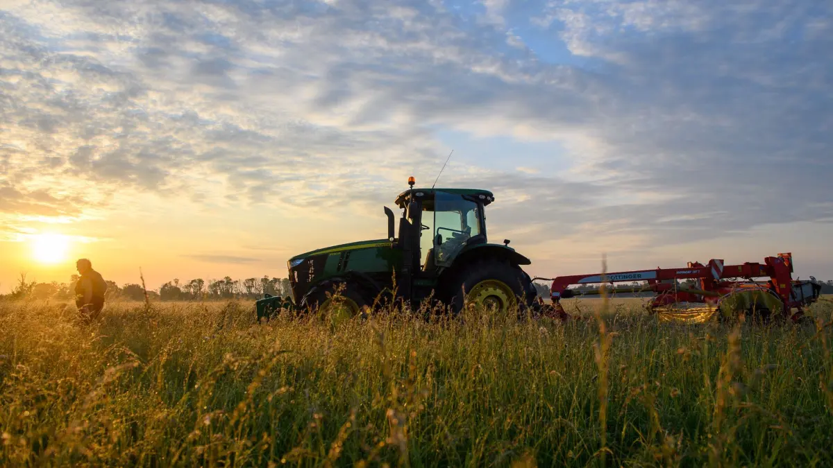 Landwirtschaft: ARCHIV - 24.05.2024, Sachsen-Anhalt, Schönebeck: Ein Traktor steht vor der aufgehenden Sonne auf einem Feld. (zu dpa: «Traktor-Unfall nach Insekten-Schreck – Mann schwer verletzt») Foto: Klaus-Dietmar Gabbert/dpa +++ dpa-Bildfunk +++