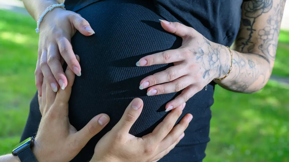 Vierlinge: Seltenes Babyglück für junges Paar im Erzgebirge: PRODUKTION - 24.06.2026, Sachsen, Chemnitz: Louise Ammon und ihr Mann Tom stehen gemeinsam vor der Frauenklinik in Chemnitz. Das Paar aus dem Erzgebirge erwartet Vierlinge. Zwei der Vierlinge sind eineiig, die anderen jeweils aus einer eigenen Eizelle entstanden. Foto: Hendrik Schmidt/dpa +++ dpa-Bildfunk +++