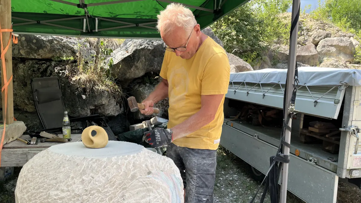 Edwin Jäckle arbeitet im Steinbruch von Gauingen an einer Möbiusschleife aus hellem Sandstein. Er nimmt zum zehnten Mal an dem Kurs teil. Steinbildhauerkurs mit Herbert Leichtle.