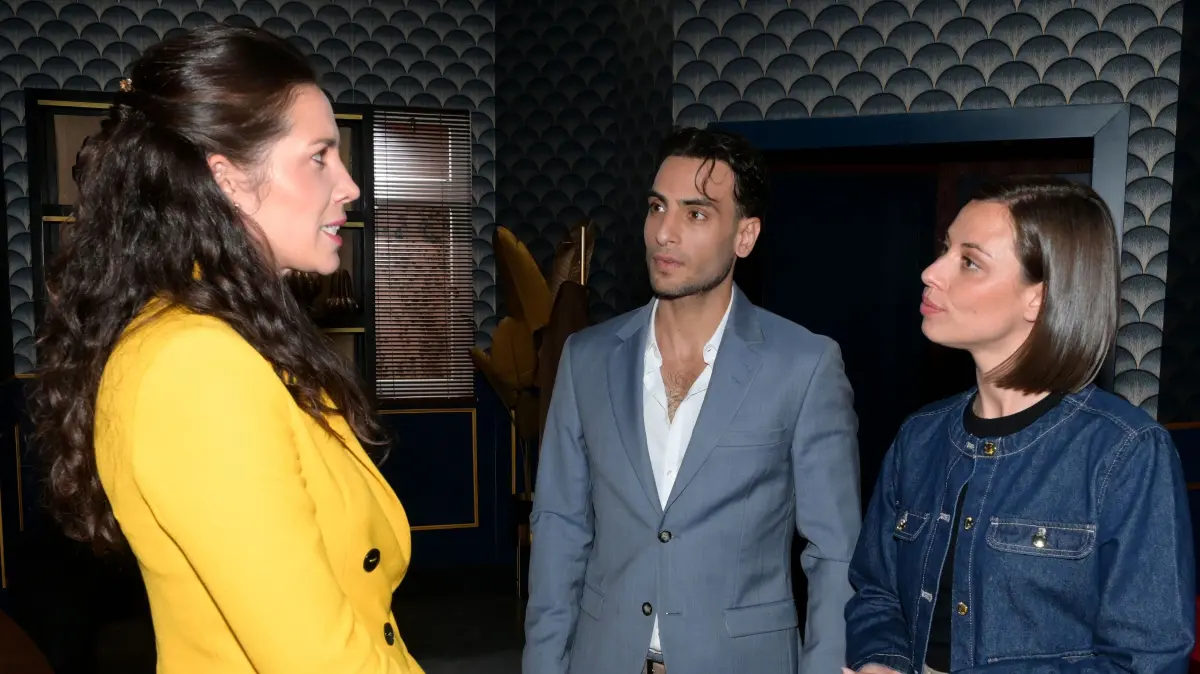 Bei dem Gespräch mit Frau Larios (Theresa Tripp, l.) muss Nihat (Timur Ülker) wieder in die Rolle von Matildas (Anna-Katharina Fecher) Verlobtem schlüpfen.