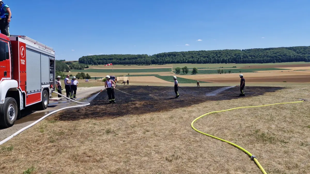 Angesichts von 30 Grad Außentemperatur und einer Einsatzstelle in der prallen Sonne gab es für die Einsatzkräfte Marscherleichterung, sobald das offene Feuer niedergeschlagen war: Sie durften für die Nachlöscharbeiten die dicken Jacken ablegen.