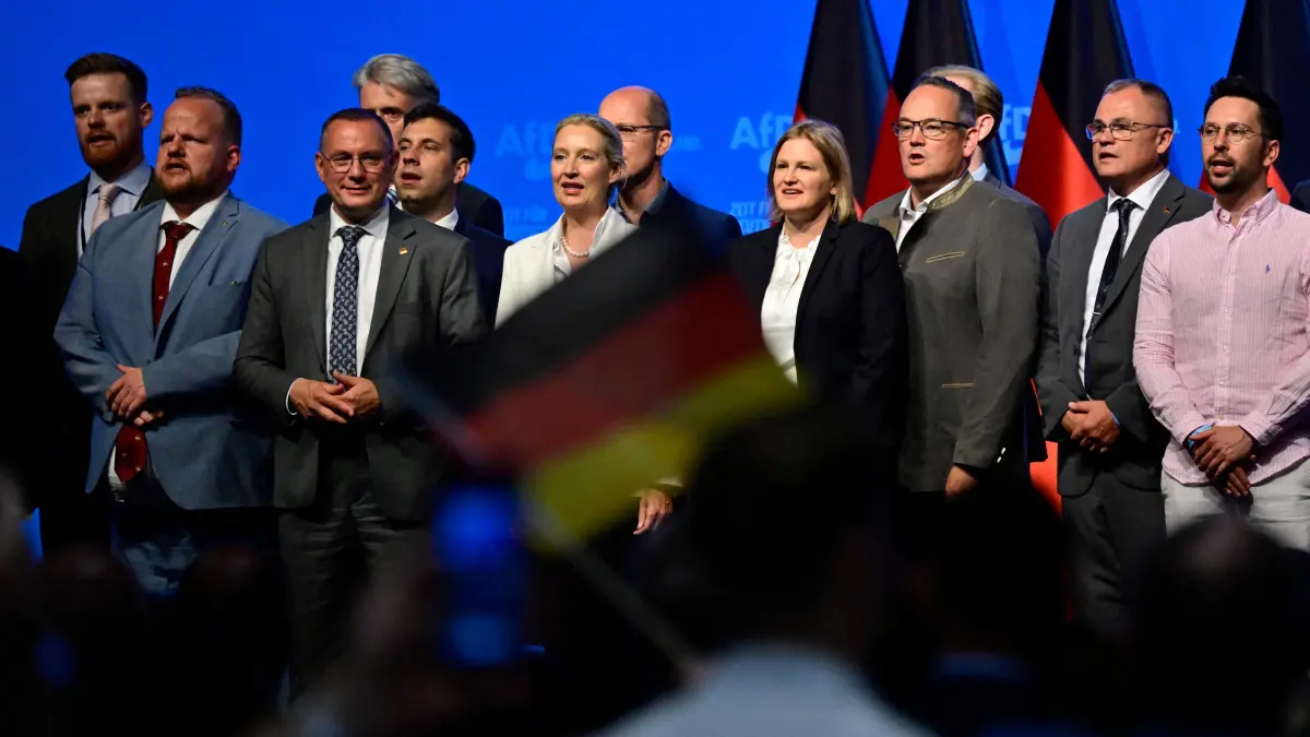 GERMANY-POLITICS-PARTIES-FAR RIGHT-AFD: AfD co-leaders Alice Weidel (front C) and Tino Chrupalla (front 2nddL) and members of the party's federal executive board sing the national anthem at the end of the party congress of far-right Alternative for Germany (AfD) at the Messe Erfurt fairground in Erfurt, eastern Germany on July 5, 2026. (Photo by John MACDOUGALL / AFP)