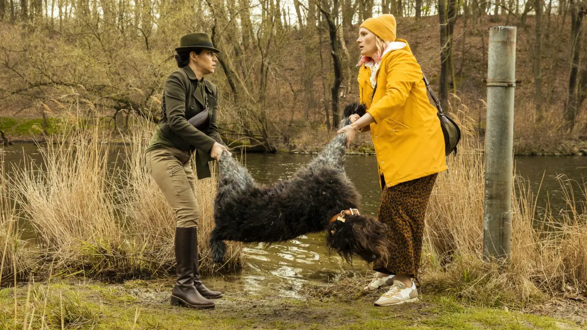 Bella (Almila Bagriacik, l.) muss Eva (Rosalie Thomass, r.) helfen, die Leiche von Hund Rocco zu verstecken, den Eva versehentlich mit Bellas Waffe erschossen hat.