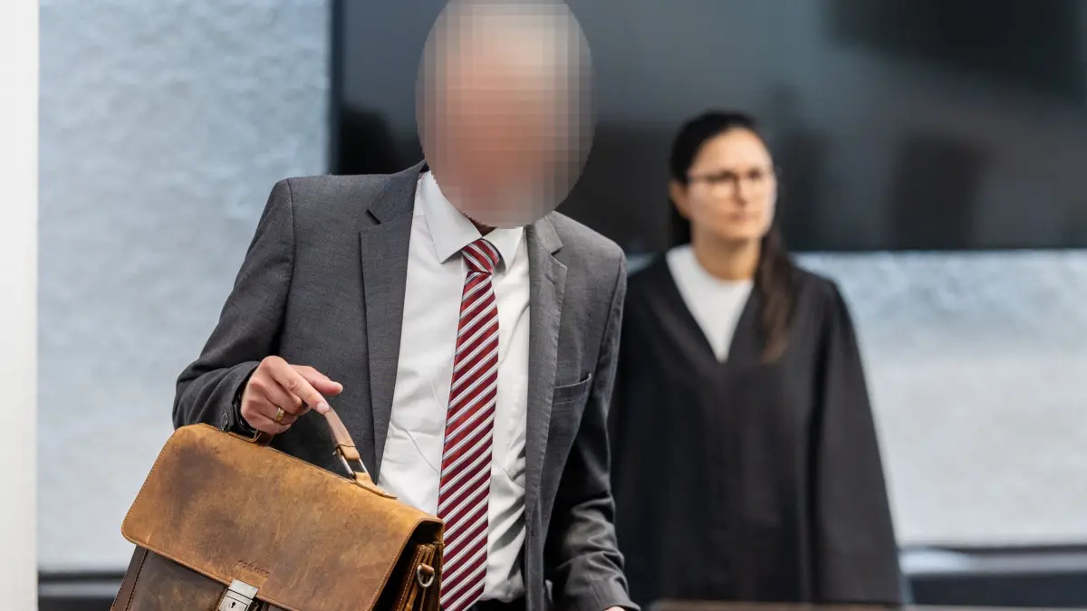 Prozess gegen freigestellten Inspekteur der Polizei: 06.07.2026, Baden-Württemberg, Stuttgart: Ein Angeklagter freigestellter Inspekteur der Polizei betritt einen Gerichtssaal des Landgerichts Stuttgart. Der vom Dienst freigestellte Inspekteur der Polizei muss sich knapp drei Jahre nach dem Freispruch wegen des Vorwurfs der sexuellen Belästigung wegen Bestechlichkeit verantworten - Er soll einer jungen Beamtin Hilfe bei der Karriere zugesichert haben, wenn sie ein Verhältnis mit ihm eingehen würde. Foto: Christoph Schmidt/dpa - ACHTUNG: Person(en) wurde(n) aus rechtlichen Gründen gepixelt +++ dpa-Bildfunk +++