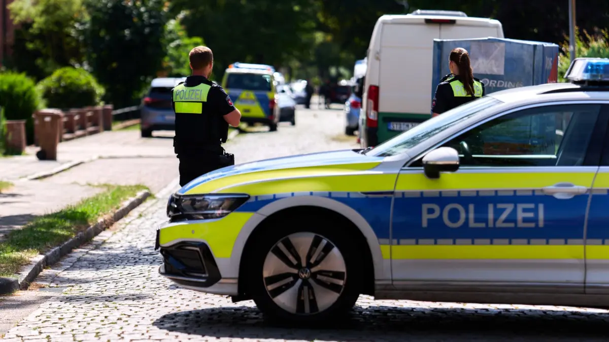 Schüsse in Jugendeinrichtung - Mehrere Tote in Stade: ARCHIV - 29.06.2026, Niedersachsen, Stade: Einsatzkräfte der Polizei stehen auf einer Straße vor einer Jugendeinrichtung. In der Einrichtung sind mehrere Menschen durch Schüsse gestorben. (zu dpa: «Stade erhöht Polizeipräsenz nach Gewalttaten») Foto: Marcus Golejewski/dpa +++ dpa-Bildfunk +++
