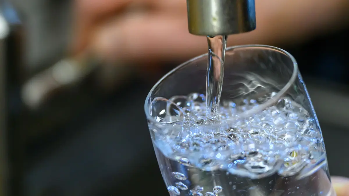Trinkwasserversorgung: ARCHIV - 24.07.2025, Sachsen, Chemnitz: Trinkwasser läuft in einer Küche in Chemnitz in ein Glas. (zu dpa: «Umweltminister ruft wegen Trockenheit zum Wassersparen auf») Foto: Hendrik Schmidt/dpa +++ dpa-Bildfunk +++