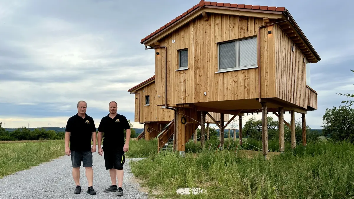 Die Projektinitiatoren und Geschäftsführer Günter Wengert und Stefan Barth vor den Baumhäusern, die sie für Übernachtungen anbieten. Am Ende der Bühlertanner Schulstraße, auf der Hochebene, ist das Hotel zu finden.