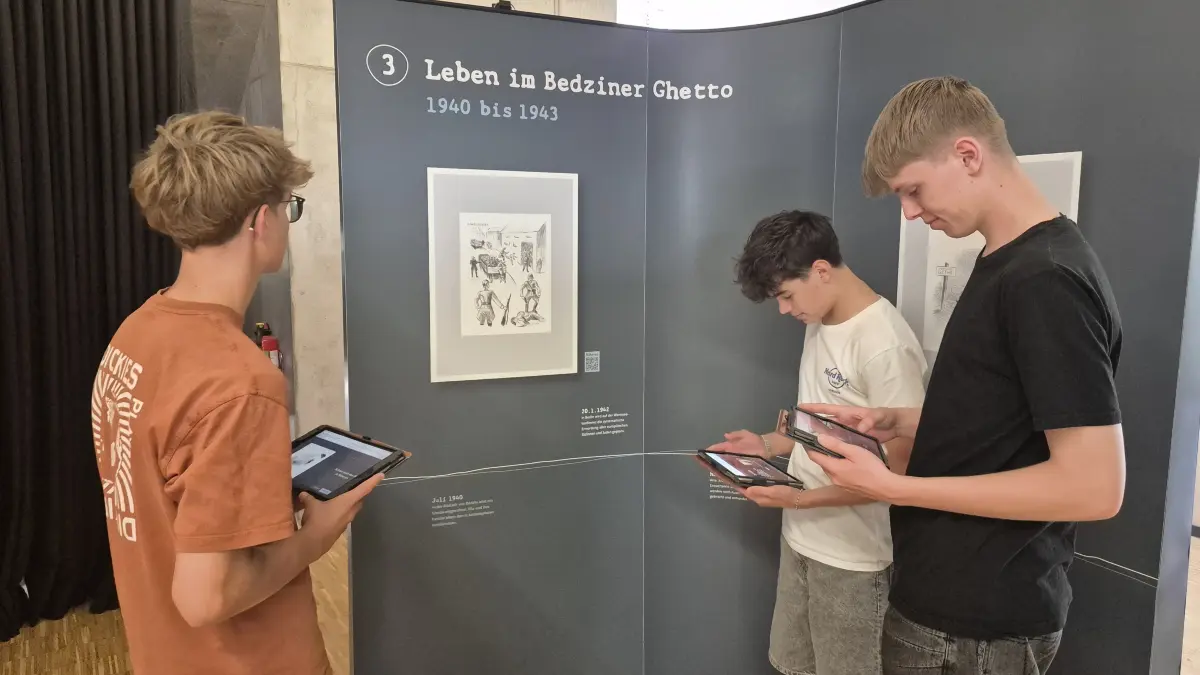 Levi Kocher, Josia Klett und Maxim Löwen aus dem Basiskurs Geschichte vor einem Bild von Ella Liebermann-Shiber in der Ausstellung im Dußlinger Karl-von-Frisch-Gymnasium.