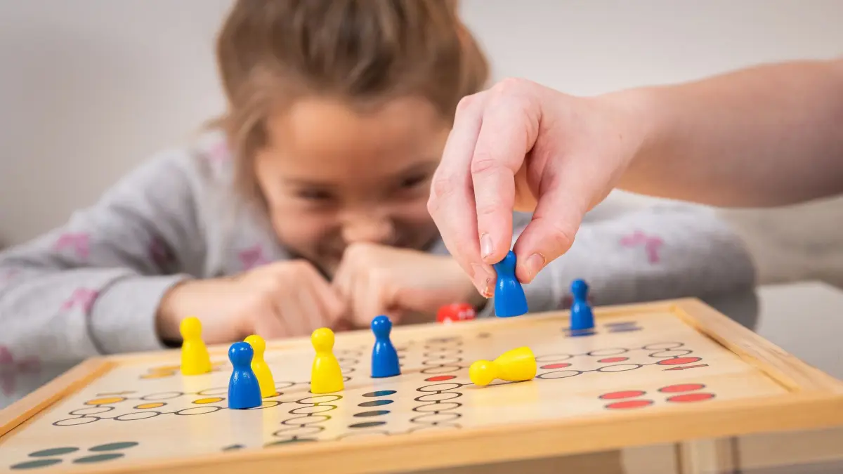 Kinder spielen „Mensch ärgere dich nicht“: ILLUSTRATION - Schadenfreude, aber auch Frustration können beim «Mensch ärgere dich nicht»-Spiel hochkommen. Dabei kann man üben, Emotionen zu benennen, etwa: «Ich sehe, du bist wütend. Möchtest du erst mal durchatmen?» (zu dpa: «Fokus: Wie lernen Schulanfänger das mit der Konzentration?») Foto: Benjamin Nolte/dpa-tmn - ACHTUNG: Nur zur redaktionellen Verwendung im Zusammenhang mit dem genannten Text - Honorarfrei nur für Bezieher des dpa-Themendienstes +++ dpa-Themendienst +++