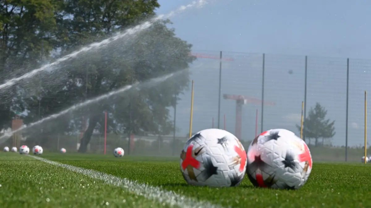 Trainingsauftakt FC Bayern Frauen: 16.07.2026, Bayern, München: Fußball: Frauen, Bundesliga, Trainingsauftakt FC Bayern München: Offizielle Spielbälle der Google-Pixel Frauen-Bundesliga liegen auf dem Platz, der mit Rasensprengern bewässert wird. Foto: Florian Diettrich/dpa +++ dpa-Bildfunk +++