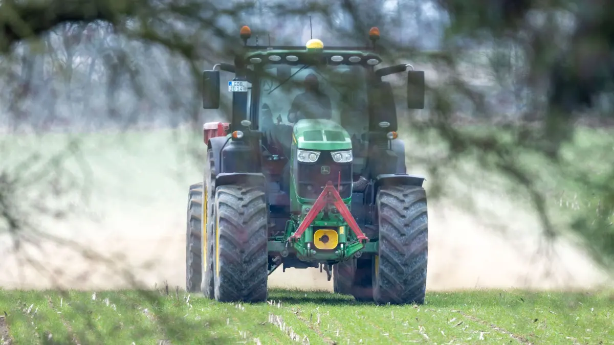 Düngemittel: ARCHIV - 24.03.2026, Mecklenburg-Vorpommern, Lützow: ILLUSTRATION: Ein Traktor fährt mit einem Streuwagen über ein Feld und verteilt Dünger. (zu dpa: «Bauernpräsident schlägt Alarm: Dünger wird immer knapper») Foto: Jens Büttner/dpa +++ dpa-Bildfunk +++