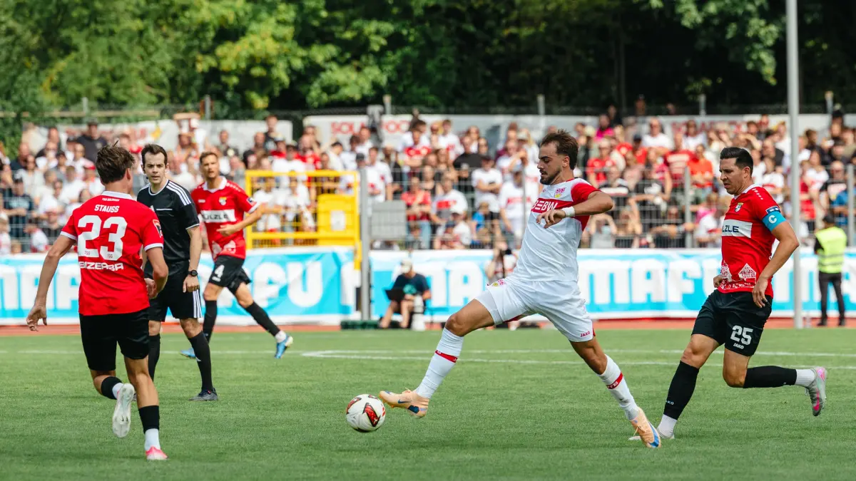 TSG Balingen vs. VFB Stuttgart, Fussball, Testspiel, Saison 2026/2027, 19.07.2026,: TSG Balingen vs. VFB Stuttgart, Fussball, Testspiel, Saison 2026/2027, 19.07.2026, Mika Stauss /TSG Balingen #23), Jovan Milosevic (VfB Stuttgart #19) am Ball und Matthias Schmitz (TSG Balingen #25)
Foto: DROFITSCH/EIBNER