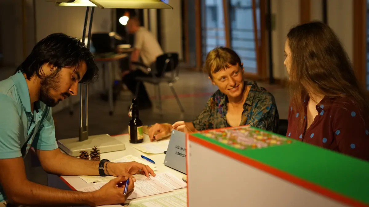 Behördengang in der Neuen 8: Die Künstlerinnen Janina Schmid (Mitte) und Johanna Mangold (rechts) erteilten im "Büro für nicht-effiziente Entwicklung" Genehmigungen für alltägliche Handlungen.