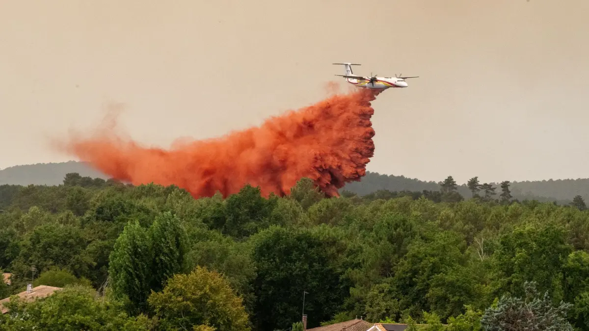 Brände in Frankreich: 23.07.2026, Frankreich, Lège-Cap-Ferret: Ein Löschflugzeug wirft bei der Bekämpfung von Waldbränden in der Region Lège-Cap-Ferret im Westen Frankreichs Wasser ab. Foto: Caroline Blumberg/AP/dpa +++ dpa-Bildfunk +++