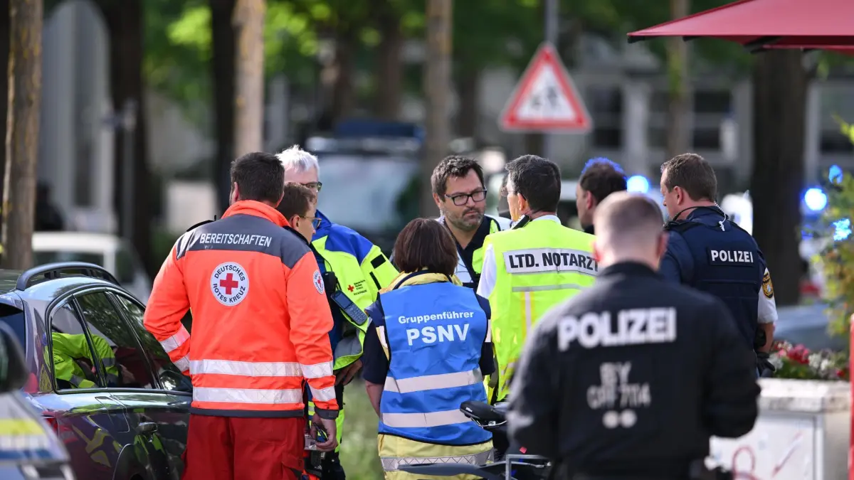 Attacke in Bank in Regensburg: 23.07.2026, Bayern, Regensburg: Unterschiedliche Einsatzkräfte besprechen sich beim Einsatz an einer Bank. Bei einem Messerangriff in einer Bankfiliale in Regensburg ist ein Mann ums Leben gekommen. Zunächst hatte die Polizei von einer Geiselnahme in der Bank gesprochen. Foto: Armin Weigel/dpa +++ dpa-Bildfunk +++