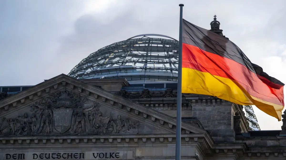 Tag der deutschen Einheit: ARCHIV - 03.10.2022, Berlin: Die Deutschlandfahnen auf dem Reichstagsgebäude, dem Sitz des Deutschen Bundestags, wehen im Wind. (zu dpa: «Ost und West, in Missmut vereint») Foto: Monika Skolimowska/dpa +++ dpa-Bildfunk +++
